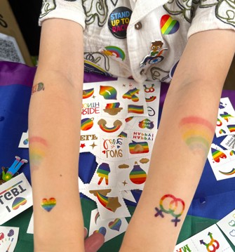 Child with temporary tattoos on arms at Cambridge Pride