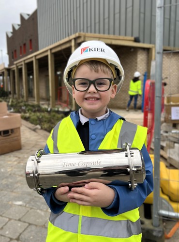 Northstowe pupil holding the time capsule outside the Unity Centre